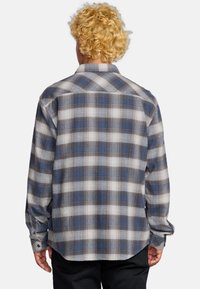 Langarm geruite overhemd in blauw, zwart en wit. Voorzien van een button-down kraag en manchetten met één knoop. Gemaakt van lichte stof.