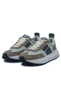 Suedesneakers och mesh med en beige och grå färgschema, tjocka gummisulor och en framträdande snörningsdesign med logotypdetaljer.