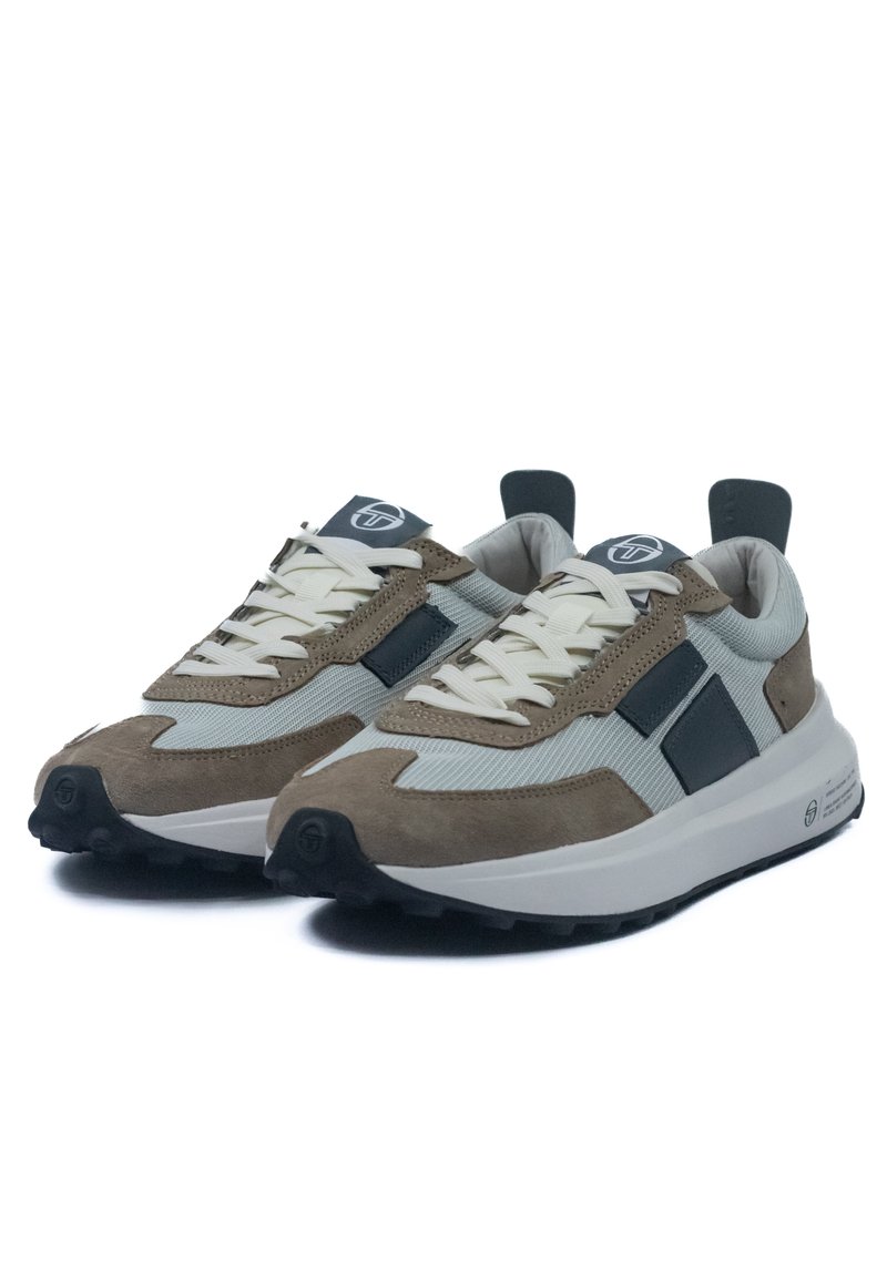 Zapatillas de ante y malla que presentan una combinación de colores beige y gris, suelas de goma gruesas y un diseño de cordones prominente con acentos de logo.