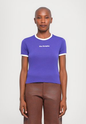 Purple fitted t-shirt with white ribbed collar and sleeves, featuring "The Kooples" printed in white text on the front.