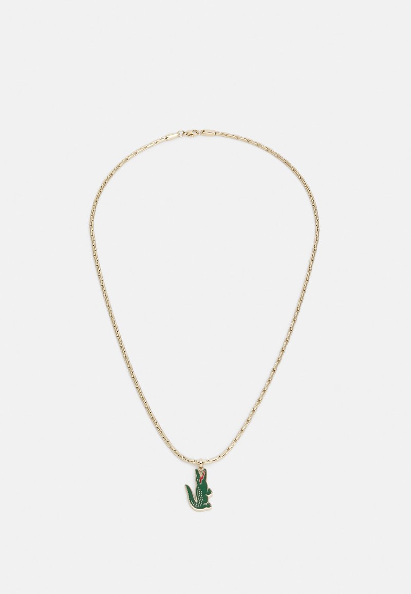 Gouden ketting met een groene krokodillenhanger met rode accenten en gestippelde details, hangend aan een schakelkettinkje.