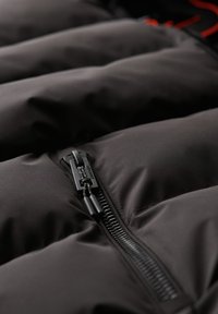 Czarna kurtka puchowa wykonana z materiału o pikowanych sekcjach, z centralnym zamkiem błyskawicznym i teksturowaną powierzchnią, idealna do izolacji i zapewnienia ciepła.