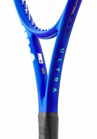 Blauwe tennisracket met een gestructureerde zwarte grip. Heeft een breed frame, snaarpatronen en "ULTRA" in lichtgroen op de zijkant gedrukt.