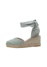 Zapato de cuña de esparto verde claro con tacón de yute trenzado, correa acolchada en el tobillo y parte superior de tejido texturizado con detalles de costura.