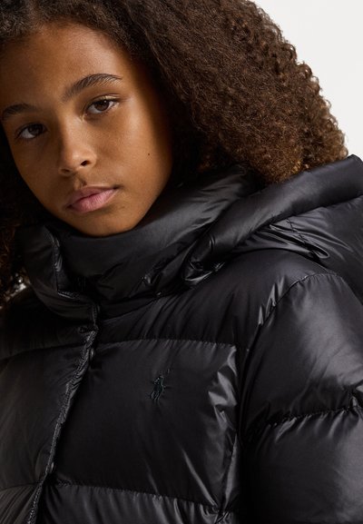 Fekete puffertakaró magas nyakkal, fényes textúrával és hímzett logóval a mellkason. Gombos záródással és steppelt mintázattal rendelkezik.