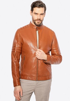 Braune Lederjacke mit Stehkragen, Reißverschluss, Schulterakzenten und vertikalen Rippdetails an den Ärmeln; durchgehend glatte Textur.