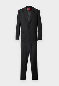 Traje negro con un blazer de dos botones y solapas con muesca, combinado con pantalones de corte recto, elaborado en una tela suave. Etiqueta de la marca roja en el interior.