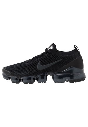 Baskets Nike Vapormax noires avec tige en maille texturée, swoosh emblématique sur le côté et semelle à coussin d'air segmentée.