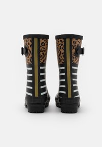 Bottes de pluie en caoutchouc noir avec un imprimé léopard et un design rayé, dotées d'un accent doré et de boucles latérales pour un ajustement.