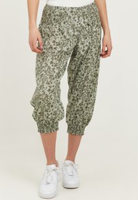 Letvægts, elastisk talje, cropped bukser i en afdæmpet grøn farve med et blomstermønster i mørkere grøn. Blødt stof med samlede ærmer.