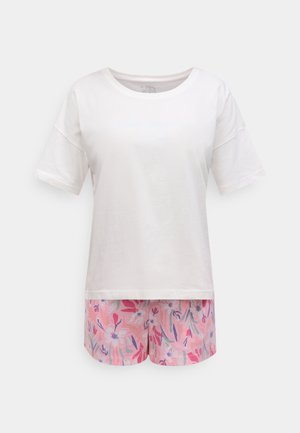 Witte katoenen top met korte mouwen en lichtblauwe tekst; gecombineerd met roze korte broek met bloemenpatroon met groene en paarse accenten.