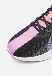 Scarpa da corsa nera e rosa con tomaia in rete, design dinamico e una accentatura azzurro chiaro. Presenta il logo Nike e un sistema di allacciatura intricato.