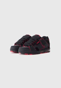 Black sneakers with red accents, featuring a textured rubber sole, reinforced toe, padded collar, and lace-up design.