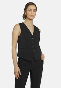 Schwarze ärmellose Weste mit tiefem V-Ausschnitt, fünf Knöpfen und Fronttaschen. Taillierter Schnitt mit glatter Textur.