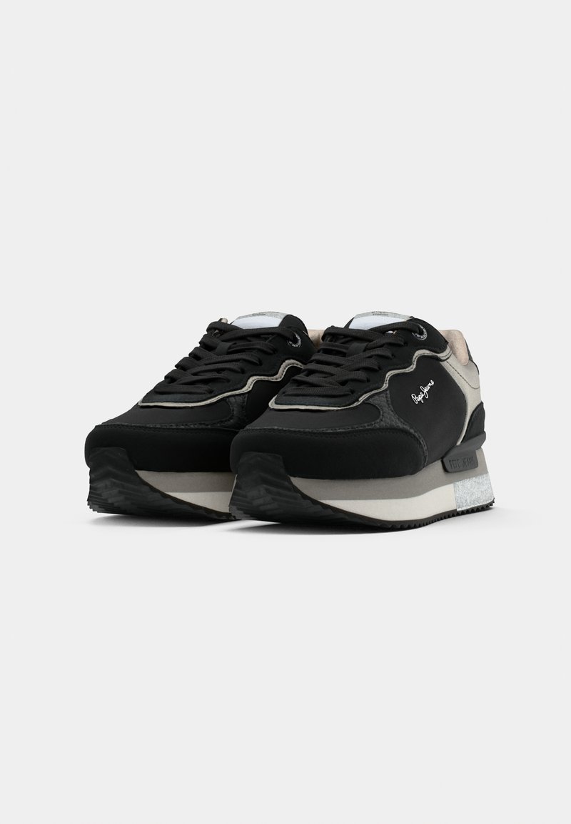 Schwarzer und grauer Sneaker mit strukturiertem Obermaterial, kontrastierender Gummisohle, abgerundeter Zehenpartie und geschichtetem Design. Verfügt über Schnürsenkel und Logodetails.