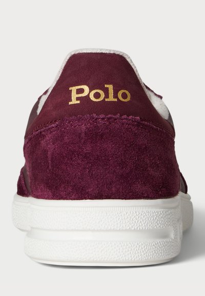 Sneaker in suede bordeaux con suola in gomma bianca. Caratterizzato dal logo dorato "Polo" sul tallone. Design minimalista con tomaia testurizzata e collo imbottito.
