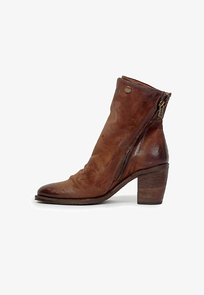 Bottine en cuir marron avec talon bloc empilé, fermeture éclair latérale et détail à bouton pression sur la tige lisse.