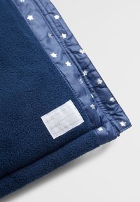 Marinblå filt i mjukt fleecematerial med en sidenkant prydd med silverstjärnmönster och en etikett för personliga meddelanden.