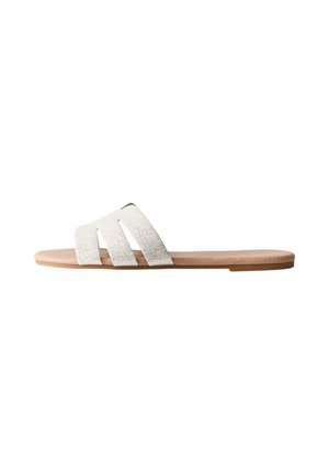 Platta slidesandaler med tre strukturerade vita remmar och en ljusbrun sula, som har en minimalistisk design och slät yta.