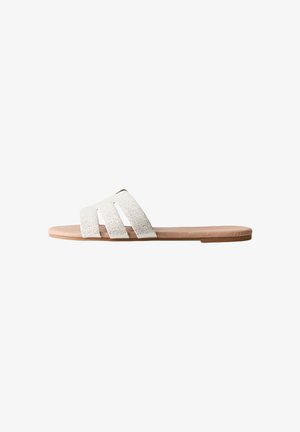 Platte slip-ons met drie getextureerde witte banden en een lichtbruine zool, met een minimalistisch design en een gladde afwerking.