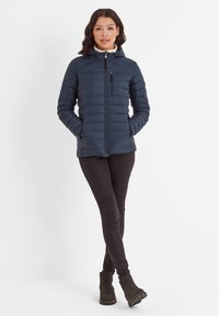 Navy puffer jacket with a zip-up front, hood, and a chest pocket. Worn over black leggings and ankle boots, featuring a quilted design.