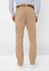 Beige katoenen broek met een rechte snit, twee achterzakken en een bruine riem; gedragen met witte sneakers en een lichtblauw gestreept shirt.