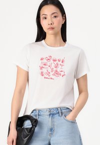 Witte katoenen t-shirt met een rode geprinte grafiek van etenswaren en de tekst "Weekendplannen." Standaard pasvorm, korte mouwen, ronde hals, casual stijl.
