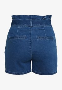 Tummo korkeavyötäröiset tummansiniset farkkushortsit, joissa on rypytetty vyötärö, takataskut ja siisti sauma. Silkeä pinta, jossa on minimaalista kulumista.