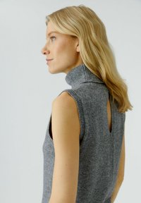 Gray knit sleeveless turtleneck sweater with a back keyhole cutout. Soft texture, fitted design, and ribbed collar detail.