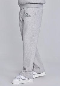 Gray sweatpants made of soft fabric, featuring an embroidered logo on the left thigh, with a relaxed fit and tapered legs.