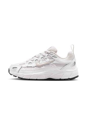 Bela in siva tekaška čevlja Nike z mrežastimi detajli, vezalkami, logotipom Swoosh in teksturiranim podplatom, prikazana v stranskem profilu na belem ozadju.