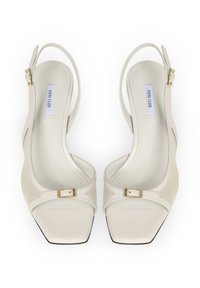 Beżowe szpilki typu slingback z kwadratowym noskiem, teksturowanym wierzchem, złotymi klamrami i wyściełaną wkładką dla wygody.