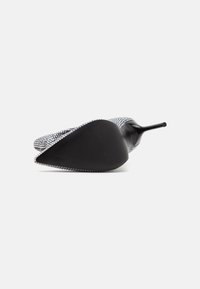 Chaussure à talon haut gris texturé avec un bout pointu et une semelle en caoutchouc noire, ornée d'un accent décoratif en rhinestones le long du bord.