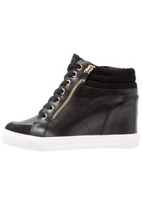 Black high-top sneakers made of leather and suede, featuring a gold zipper detail, round laces, and a white rubber sole.