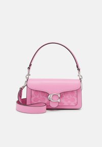 Sac à main rose en cuir et tissu avec fermoir argenté en forme de "C", poignée courte et bandoulière amovible sur fond blanc.
