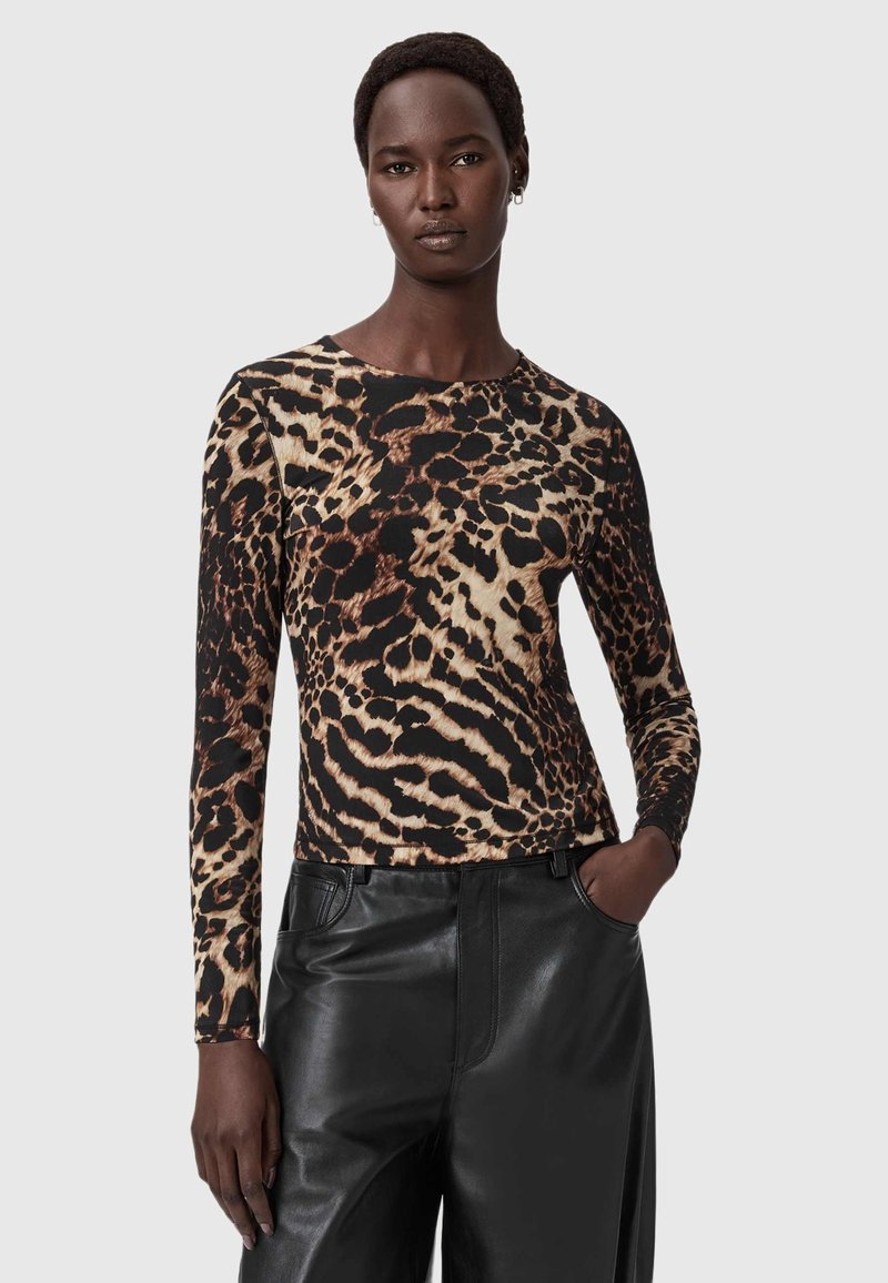 Brūnas un melnas leoparda raksta garām piedurknēm topiņš ar pieguļošu griezumu un apaļu izgriezumu, kas apvienots ar augsta vidukļa melnām ādas biksēm.