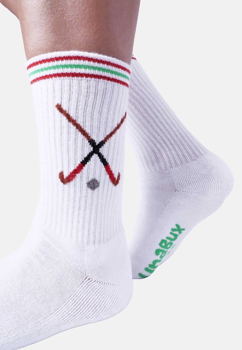 Calzini bianchi di cotone con trama a coste, con bordi a righe rosse, verdi e rosse, e grafica di una stecca da hockey con disco. Logo verde sulla suola.