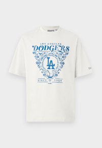 Hvid bomuldstrøje med blåt grafisk tekst "LOS ANGELES DODGERS" og "SINCE 1958" med blomsterdetaljer og "LA" logo i midten.
