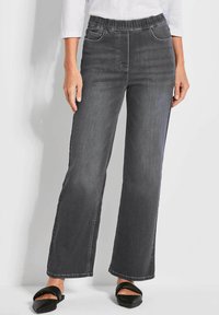 Dunkelgraue weite Jeans mit elastischem Bund, zwei Vorderaschen und glatter Textur, kombiniert mit schwarzen flachen Schuhen.