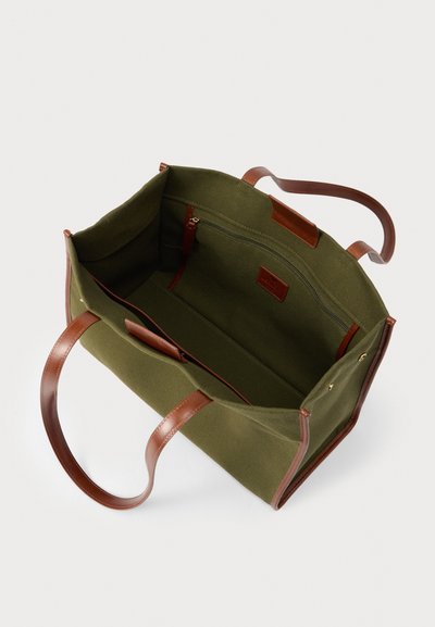 Μεγάλη τσάντα ώμου σε ελιά πράσινο χρώμα με καφέ δερμάτινες λαβές και λεπτομέρειες, διαθέτει εσωτερική τσέπη με φερμουάρ και ανοιχτή θήκη.