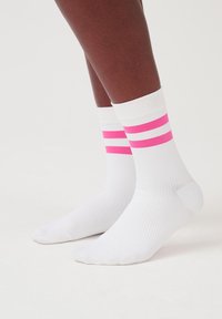 Weiße Sportsocken mit pinken und weißen Streifen am oberen Rand. Das Material ist gerippt, und das Design umfasst eine verstärkte Ferse und Zehen.