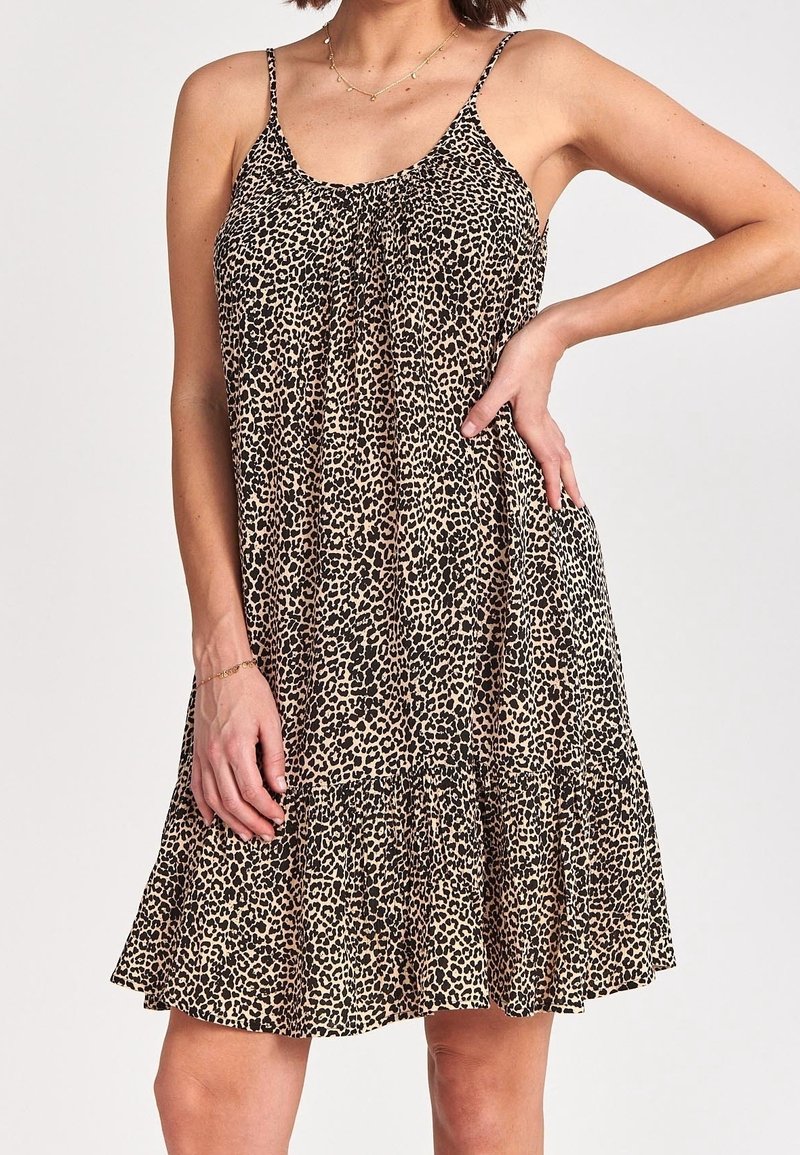 Robe d'été à imprimé léopard avec bretelles fines, ourlet évasé et corsage froncé. Fabriquée en tissu léger de couleur beige et noir.