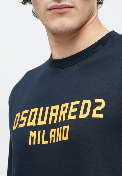Mørkeblå sweatshirt med stor gul "DSQUARED2 MILANO"-tekst. Ribstrikket rund halsudskæring, blødt bomuldsstof med en glat tekstur.