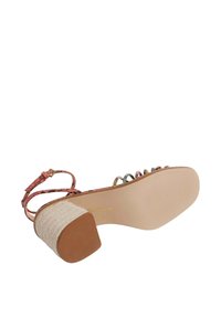 Riemchen-Heelsandale mit einem strukturierten pinken Obermaterial, mehrfarbigen Akzenten und einem geflochtenen beigen Absatz. Gummisohle mit horizontalen Rillen.