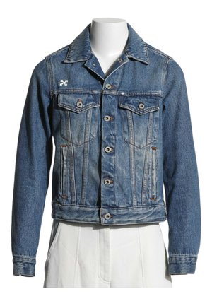 Blå denimjakke med knapper foran, to brystlommer med klapper, sidelommer og et lille hvidt broderet logo på venstre bryst.