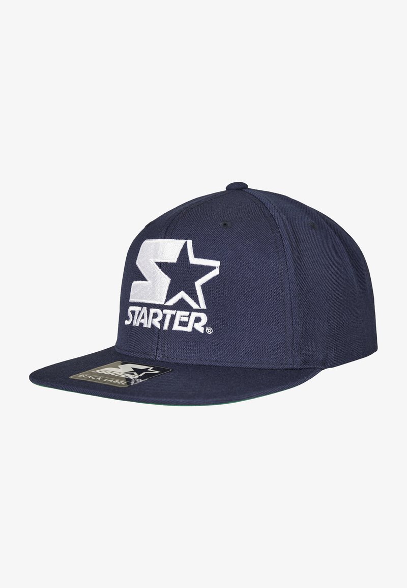 Marineblaue Snapback-Cap aus Stoff, mit gesticktem weißen "S" und Stern-Logo, flacher Schirm und einem schwarzen Etikett auf der Unterseite.