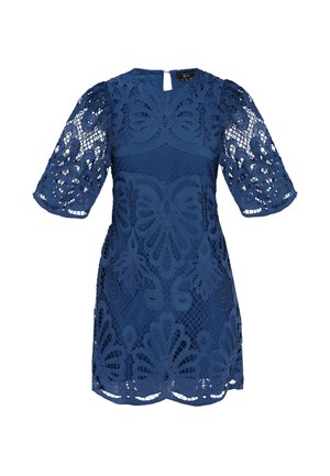 Navy zila mežģīņu kleita ar pūtīšu piedurknēm, sarežģītām izgrieztām ziedu rakstiem un atslēgas formu aizmugurē. Tekstūrēta auduma un pieguļoša silueta.