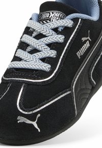 Sneaker Puma negre cu sireturi albastre, logo-uri argintii Puma și branding Hot Wheels Monster Trucks pe limbă.