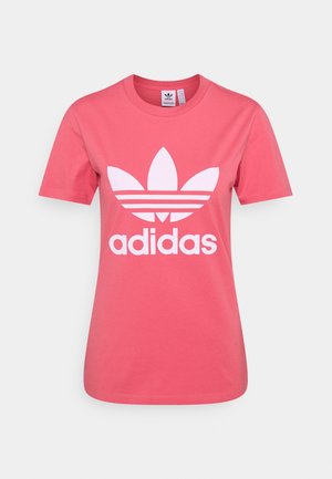 Koralowy różowy T-shirt Adidas z białym logotypem trefoil i napisem „adidas” z przodu, krótkie rękawy i okrągły dekolt.