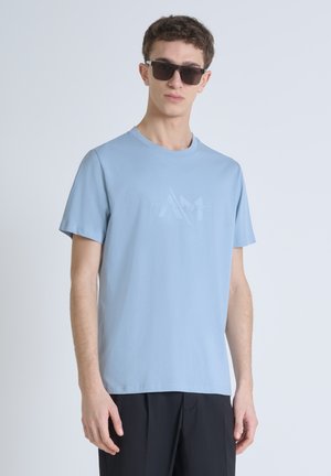Lichtblauw, kortmouwig t-shirt met een ronde halslijn en een tonale logo op de borst. De stof is glad en iets rekbaar.